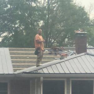 Apex worker smiling on top of a new roof he is putting on in Eatonton, GA